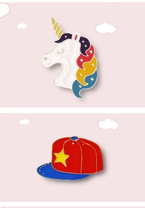 Detailed macro of unicorn and baseball cap enamel pins with colorful star accents
