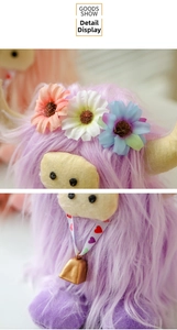 Detail of lavender Highland Cow plush with colorful floral crown and gold bell accessory