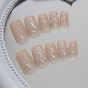 Short square press-on nails with nude pink base and delicate white daisy floral design