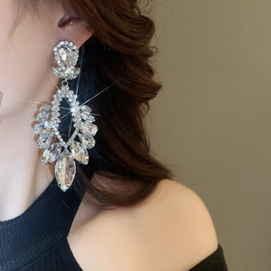 Gros plan de boucles d'oreilles pendantes avec effet d'étoile étincelant sur modèle