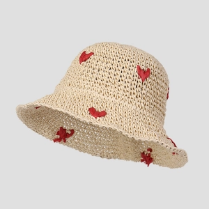 Detail of crochet straw hat with red heart embroidery and breathable hollow weave pattern