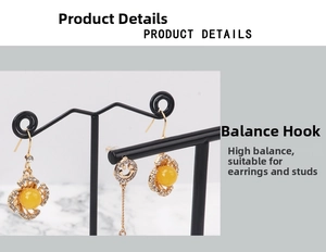 Detail of gold-plated flower earrings with yellow beads and smiley face charms