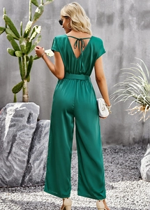 Detail view of green wide-leg jumpsuit showing V-shaped backless design and tie detail
