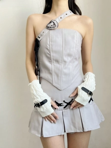 Detail view of white knitted arm sleeves with leather buckles and purple corset top