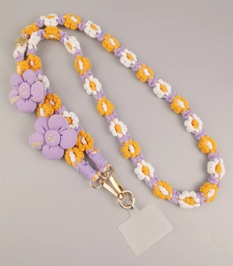 Detailed shot of handmade woven crossbody phone strap with purple floral accents and gold clasp