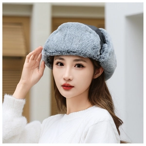 Close-up of grey faux fur winter trapper hat with warm plush lining and ear flaps