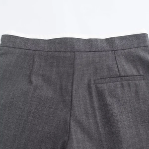 Close-up of the herringbone pattern fabric and tailored back pocket of these grey trousers