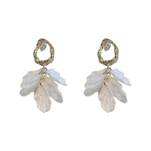 Boucles d'oreilles pétales acryliques avec anneau doré et zircone sur fond blanc