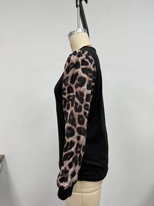 Detail of leopard print bubble sleeves and ribbed cuffs on a long-sleeve patchwork top