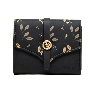 Detailed view of women's trifold wallet featuring leaf prints and a gold leaf metal buckle
