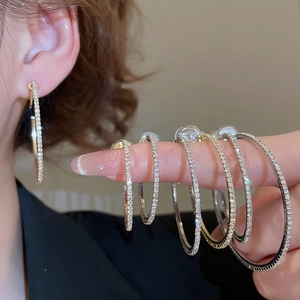 Close-up of sparkling diamond-encrusted round hoop earrings in gold and silver finishes
