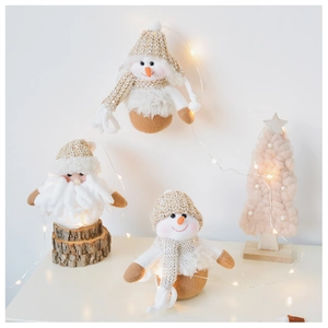 Detail of Christmas snowman and Santa plush dolls with warm LED lighting and knit textures
