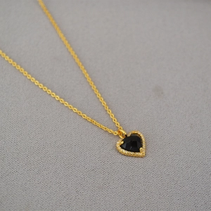 Macro detail of heart pendant with black faceted stone and micro-pave cubic zirconia