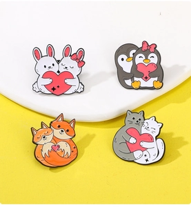 Detail of colorful enamel animal brooches featuring cats and penguins with hearts