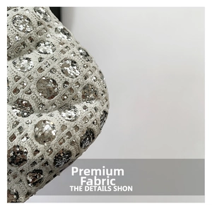 Gros plan sur tissu tricoté blanc avec paillettes argentées sur petit sac bandoulière