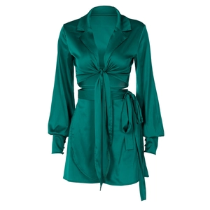 Détail macro de la robe en satin vert foncé avec taille nouée et texture soyeuse et lisse
