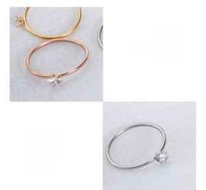 Detailed view of three minimalist 18K gold plated titanium steel rings with cubic zirconia