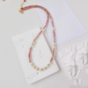 Close-up of pink natural stone beads and freshwater pearls on a beaded necklace