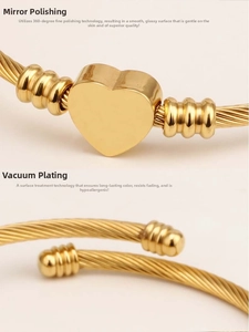Detailed macro view of gold-plated twisted cable bracelet with heart charm and mirror finish