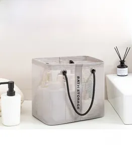 Close-up of grey mesh bath storage bag with black handles in a modern bathroom setting