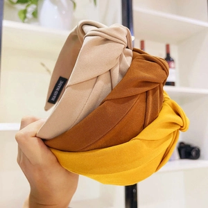 Detailed view of handmade fabric knot headbands in beige, caramel and mustard yellow
