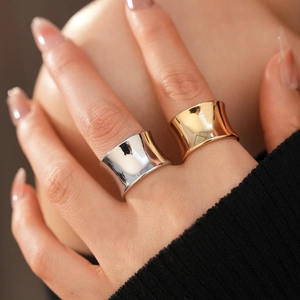 Close-up of minimalist gold and silver wide geometric rings with concave design