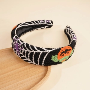 Detail of Halloween knitted headband with spider web, pumpkin and purple spider patterns