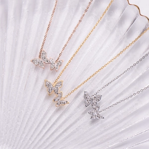 Detail of three bow-knot butterfly necklaces in gold, silver, and rose gold with pavé crystals