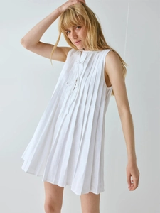 Gros plan d'une robe blanche plissée sans manches avec lien de serrage à la poitrine