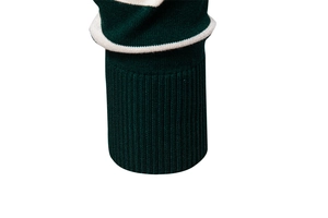 Detailed view of dark green ribbed knit cuff with white stripe pattern on sweater