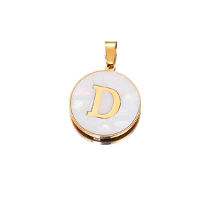 Macro shot of gold letter D pendant with white shell inlay and round metal frame