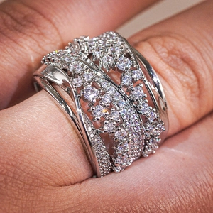 Close-up of wide silver ring with multi-layer crisscross design and pavé cubic zirconia