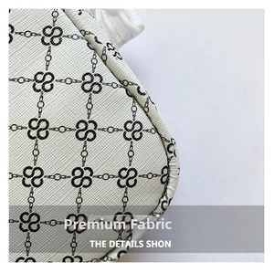 Macro shot of cream cross-grain faux leather with elegant chain print and precise stitching