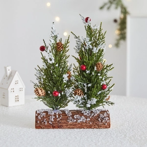 Mini snowy Christmas trees with red berries and pinecones on wooden bases for home decor
