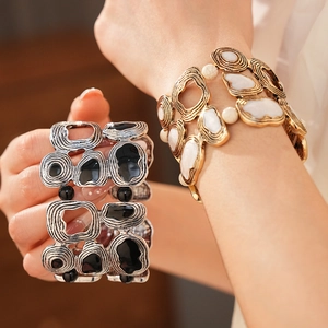 Close-up of vintage geometric elastic bracelets with gold and silver wave textures