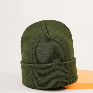 Close-up of dark green knitted beanie showing thick wool texture and folded cuff detail