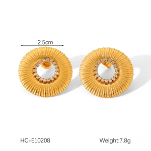 Detail of 18K gold stainless steel earrings with sunburst texture and small diamonds