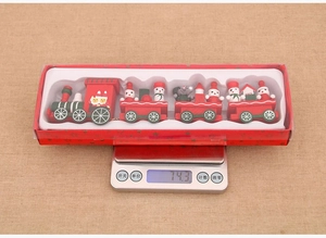 Detail showing red wooden Christmas train weight of 74.3 grams on a digital scale