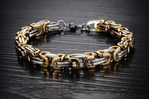 Detail of two-tone gold and silver stainless steel square link chain bracelet for men