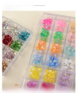 Detailed top view of a transparent 12-slot storage box with colorful nail art rhinestones