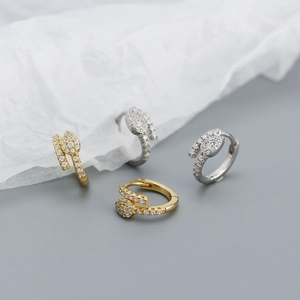 Detail of snake-shaped silver earrings with sparkling zircon inlay in gold and silver finish