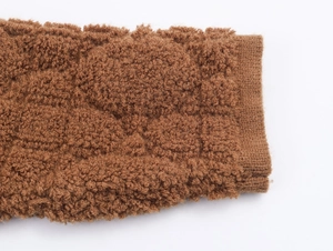 Dettaglio della texture in ecopelliccia marrone e dei polsini a costine caldi