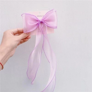 Detail of purple organza ribbon bow hair clip with reinforced stitching for girls
