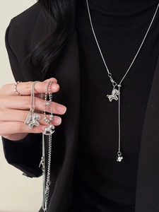 Detail of zircon-encrusted rocking horse pendant and Y-shaped chain on model