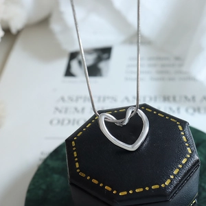 Polished silver heart pendant necklace on black gift box with sleek snake chain