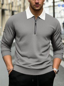 Close-up of men's polo shirt with waffle texture and metal zipper on white collar