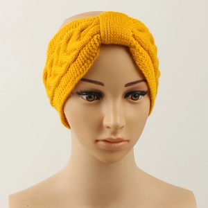 Detail of yellow knit headband with warm cable stitch and twist knot design on model