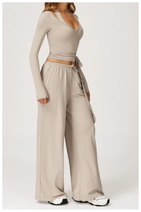 Detail of greige yoga set showing crossover tie-up top and drawstring wide-leg pants