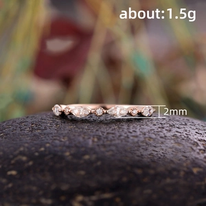 Makroaufnahme: 2mm Roségoldring mit Marquise- und runden Zirkonia auf dunklem Stein