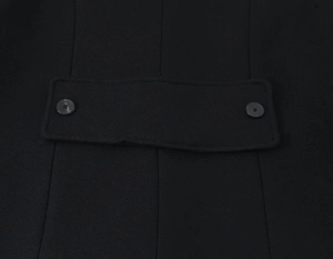 Close-up of black wool jacket featuring side waist adjustment tabs with double buttons
